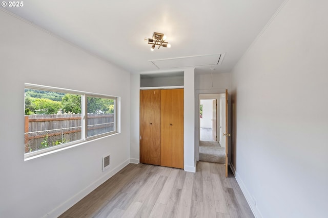 93753 E Mill Ln, Coos Bay, OR 97420 - unfurnished bedroom with attic access, light wood-style floors, baseboards, and a closet