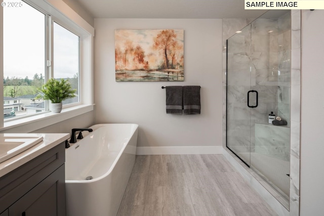 8002 N Haregrave St, Camas, WA 98607 - full bath featuring a stall shower, vanity, wood finished floors, a freestanding tub, and baseboards