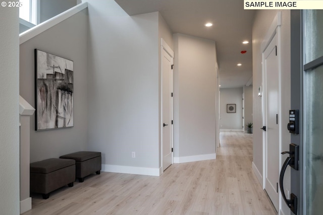 hallway featuring light wood-type flooring, baseboards, and recessed lighting