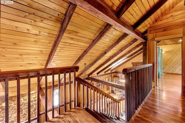 staircase with hardwood / wood-style flooring, wooden ceiling, wood walls, and vaulted ceiling with beams