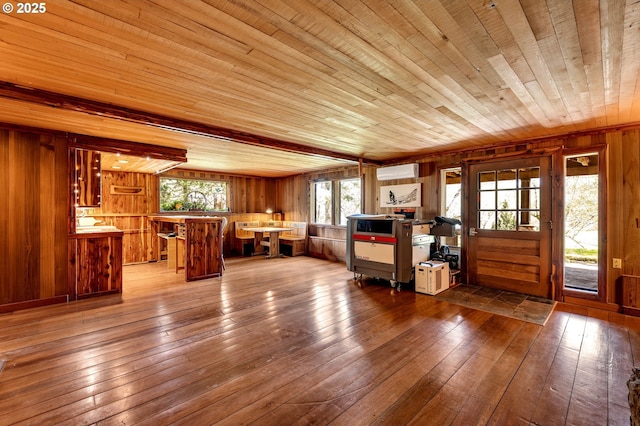interior space featuring wood ceiling, an AC wall unit, wood walls, and wood-type flooring