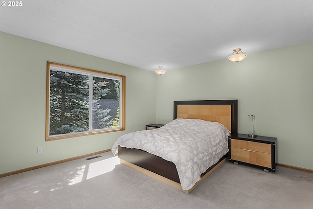 carpeted bedroom featuring baseboards and visible vents