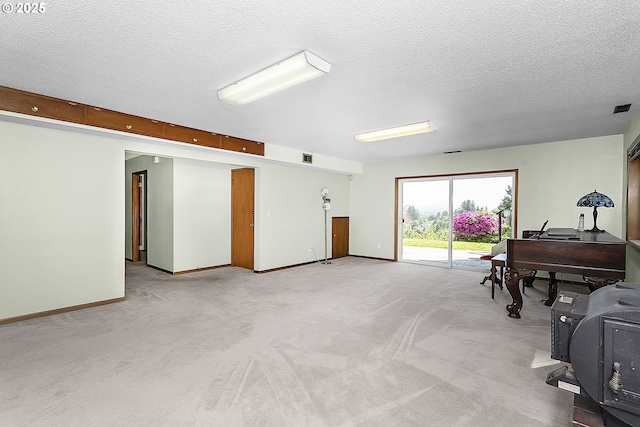 interior space with light carpet, a textured ceiling, baseboards, and visible vents