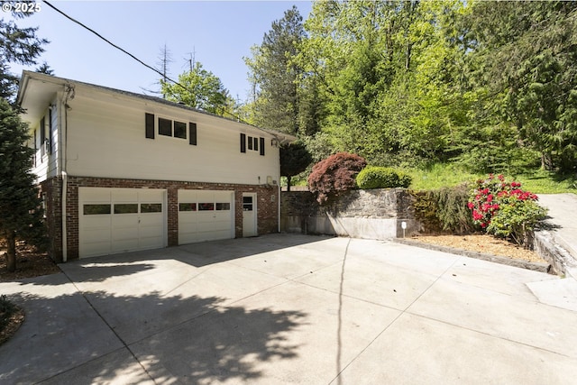 view of side of home with concrete driveway and brick siding