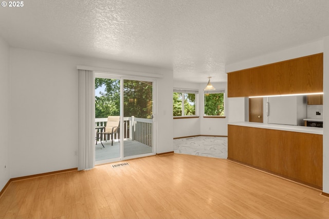16149 SW Snapdragon Ln, Tigard, OR 97223 - unfurnished living room with a textured ceiling and light wood-type flooring