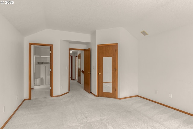 16149 SW Snapdragon Ln, Tigard, OR 97223 - unfurnished bedroom with lofted ceiling, light carpet, a textured ceiling, and connected bathroom