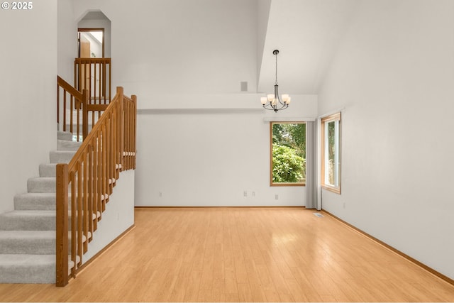 16149 SW Snapdragon Ln, Tigard, OR 97223 - unfurnished room featuring wood finished floors, a chandelier, stairway, and high vaulted ceiling