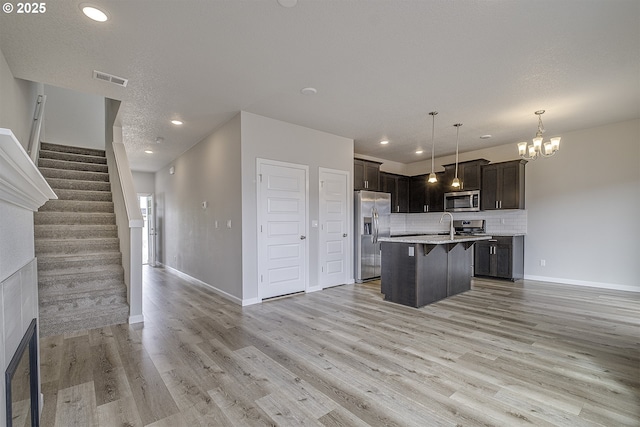 50 Shore Dr, Saint Helens, OR 97051 - kitchen with appliances with stainless steel finishes, open floor plan, light countertops, light wood-style flooring, and tasteful backsplash