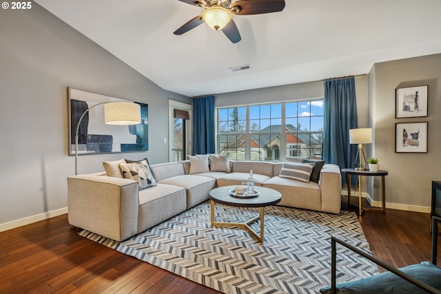 living area featuring vaulted ceiling, dark wood-type flooring, visible vents, and baseboards