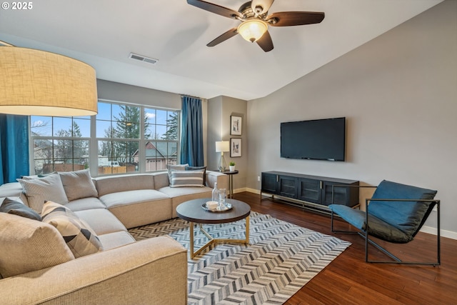 living room with vaulted ceiling, wood finished floors, visible vents, and baseboards