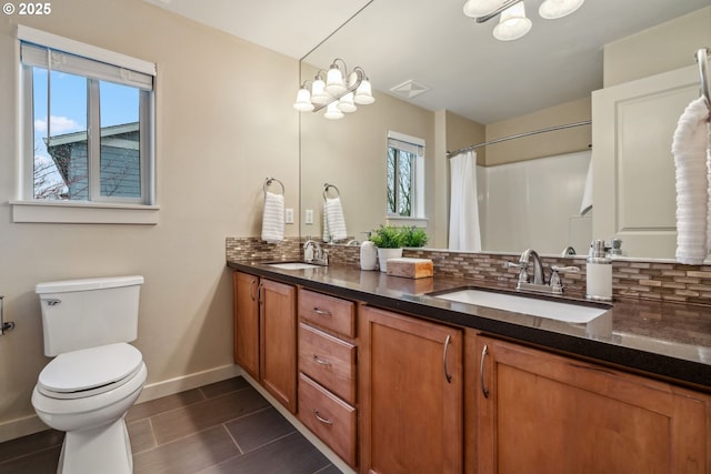 bathroom with a sink, decorative backsplash, and double vanity