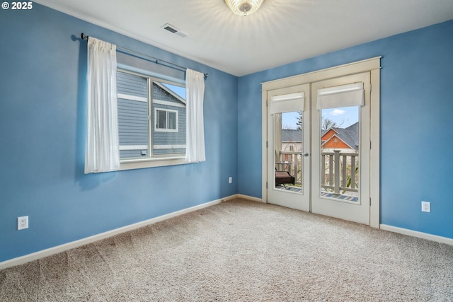 unfurnished room featuring carpet floors, visible vents, and baseboards