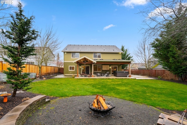 rear view of property featuring a fire pit, a yard, a patio area, and a fenced backyard