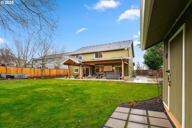 rear view of property with a patio area, a hot tub, a fenced backyard, and a yard