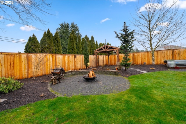 view of yard featuring a fenced backyard, a fire pit, and a gazebo