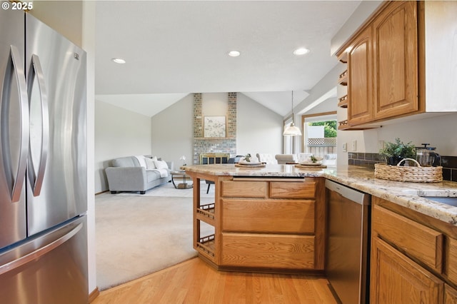 8355 SW 159th Pl, Beaverton, OR 97007 - kitchen with stainless steel appliances, a peninsula, vaulted ceiling, light stone countertops, and light wood-type flooring