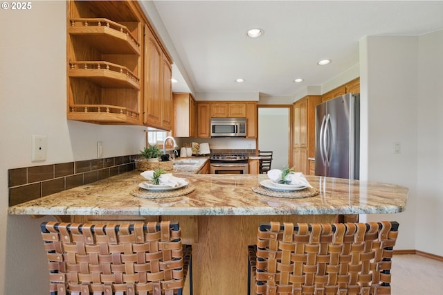 8355 SW 159th Pl, Beaverton, OR 97007 - kitchen with stainless steel appliances, a sink, light stone countertops, a peninsula, and recessed lighting