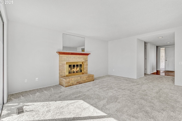 unfurnished living room with carpet floors, a fireplace, and visible vents