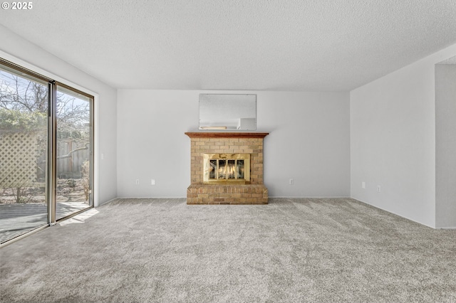 unfurnished living room featuring a brick fireplace, carpet flooring, and a textured ceiling