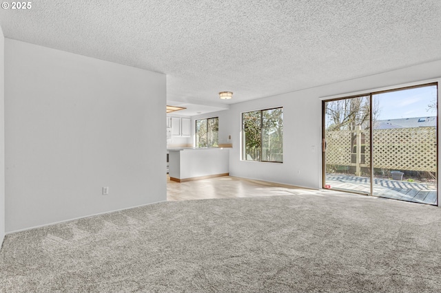 unfurnished living room with a textured ceiling and carpet