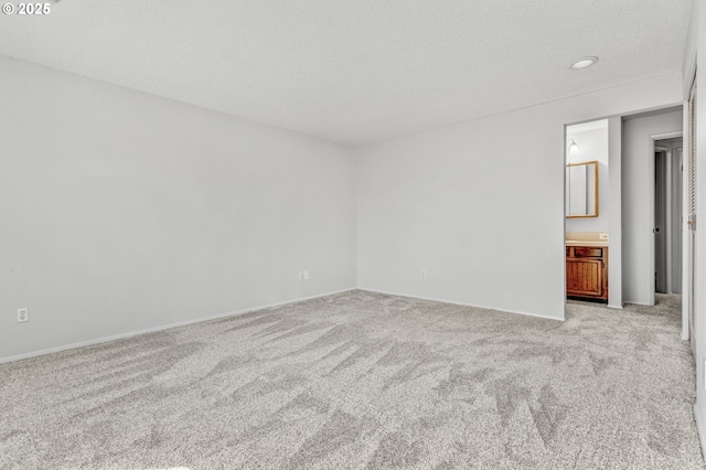 spare room with recessed lighting, light carpet, and a textured ceiling