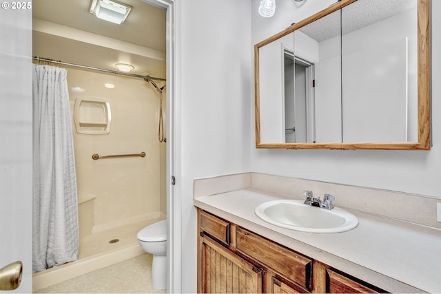 full bath featuring a stall shower, vanity, toilet, and a textured ceiling