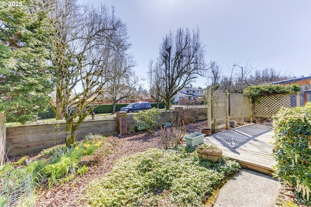 view of yard featuring fence and a deck