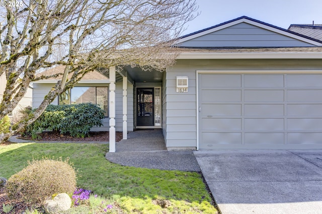 single story home featuring a garage, a front yard, and concrete driveway