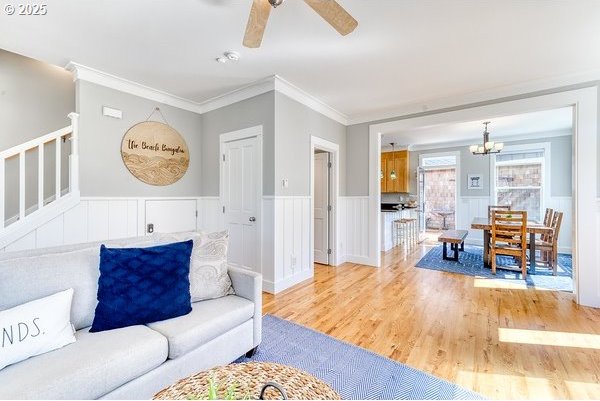 2752 SW Beach Ave, Lincoln City, OR 97367 - living room with wainscoting, crown molding, light wood-style flooring, and a decorative wall