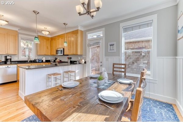 2752 SW Beach Ave, Lincoln City, OR 97367 - dining area featuring wainscoting, a chandelier, crown molding, and light wood-style flooring
