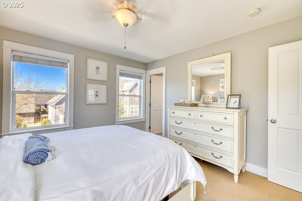 2752 SW Beach Ave, Lincoln City, OR 97367 - bedroom with baseboards, multiple windows, light carpet, and ceiling fan