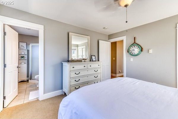2752 SW Beach Ave, Lincoln City, OR 97367 - bedroom with light tile patterned flooring, connected bathroom, baseboards, and a ceiling fan