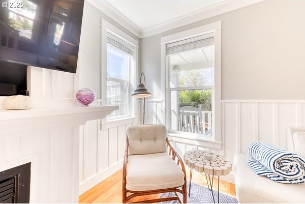 2752 SW Beach Ave, Lincoln City, OR 97367 - sitting room with crown molding, wainscoting, a decorative wall, and light wood-style flooring