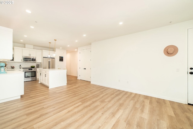 kitchen with a center island, stainless steel appliances, light countertops, and recessed lighting