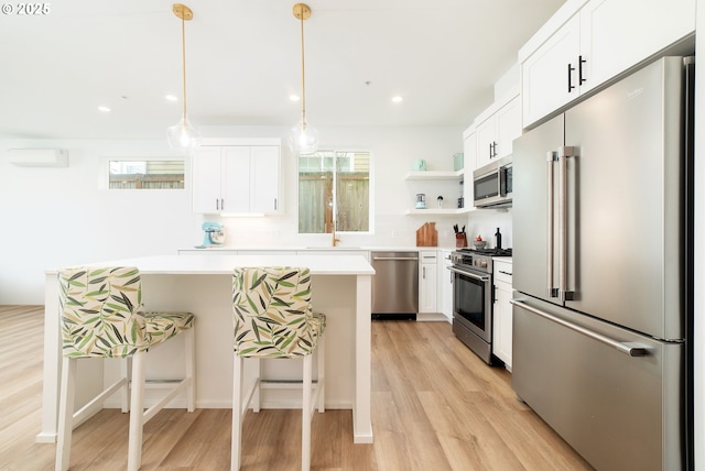 kitchen with a wealth of natural light, high quality appliances, light countertops, and a kitchen island
