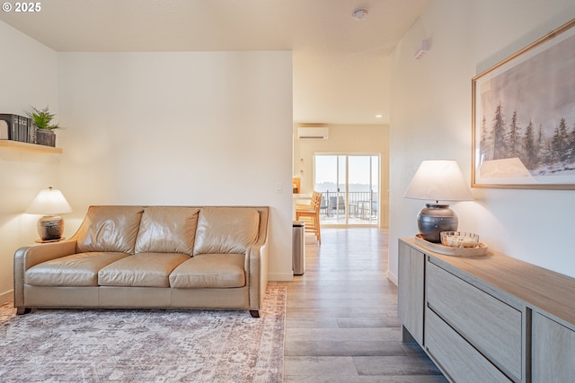 living room featuring a wall mounted air conditioner and light hardwood / wood-style floors