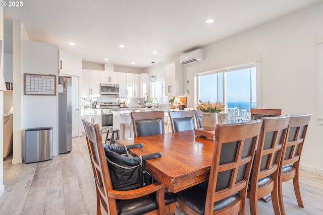 dining area featuring a wall unit AC and light wood-type flooring