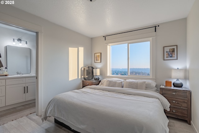 bedroom featuring connected bathroom, vaulted ceiling, and a textured ceiling