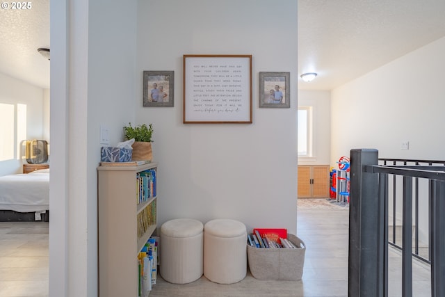 hall with hardwood / wood-style floors and a textured ceiling