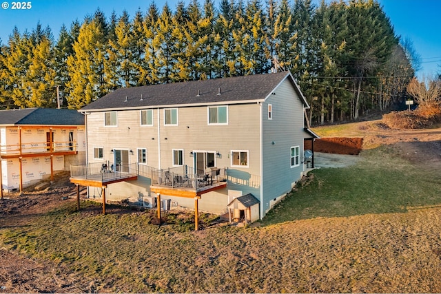 rear view of property featuring a wooden deck, a yard, and cooling unit