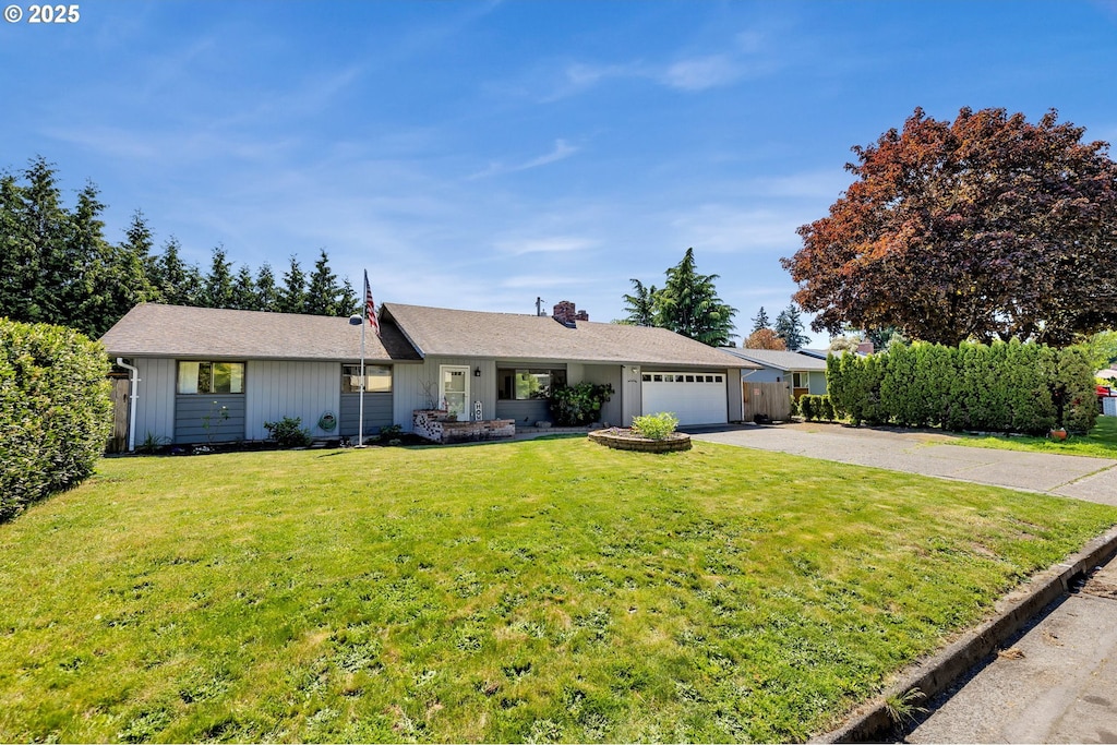 ranch-style house with driveway, a garage, and a front yard