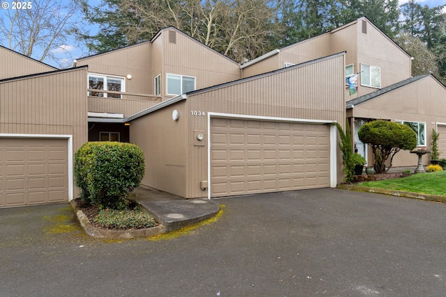 townhome / multi-family property featuring a balcony, an attached garage, and driveway