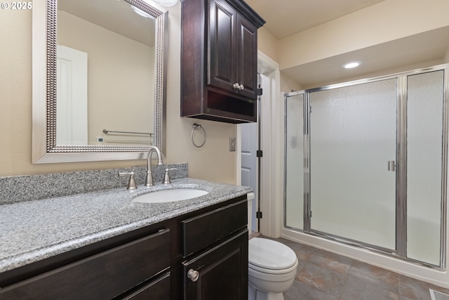 bathroom featuring recessed lighting, vanity, toilet, and a shower stall