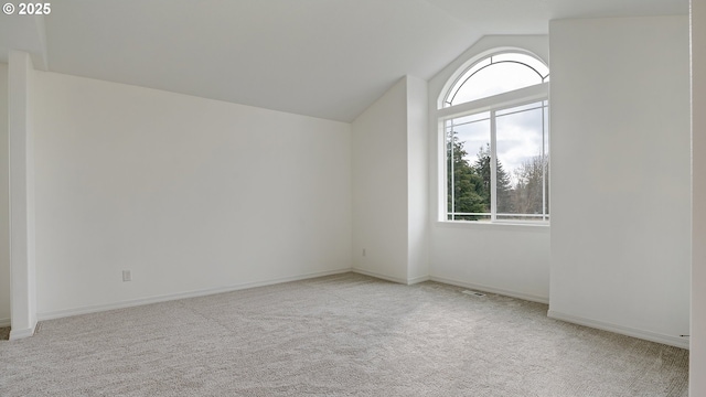 empty room with vaulted ceiling, baseboards, a wealth of natural light, and carpet floors