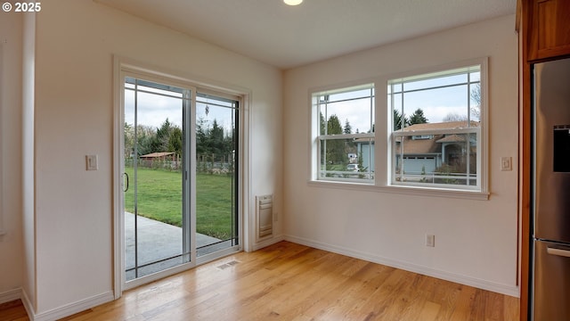 interior space featuring visible vents, light wood-type flooring, and baseboards