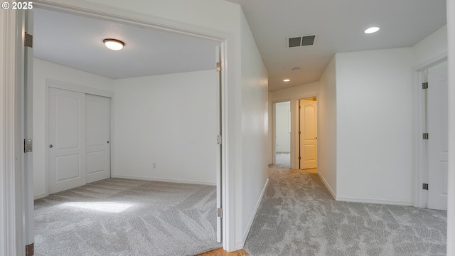 corridor with recessed lighting, visible vents, baseboards, and carpet flooring