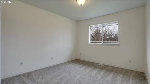 carpeted spare room featuring visible vents and baseboards