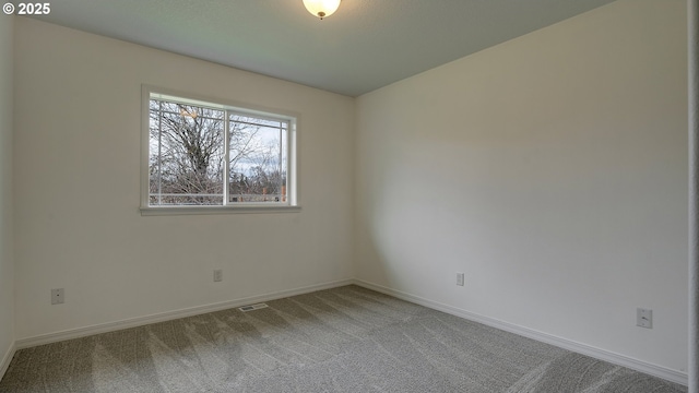 spare room featuring visible vents, baseboards, and carpet