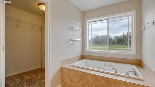 full bath with a spacious closet and a bath