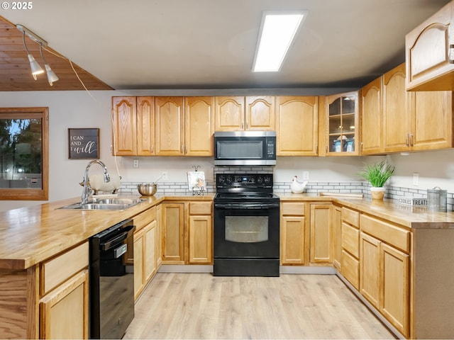 kitchen with sink, light brown cabinets, wood counters, light hardwood / wood-style floors, and black appliances